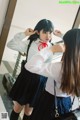 A woman in a school uniform is putting on her hair.