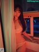 A woman in a white lingerie leaning against a window.