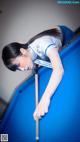 A woman leaning over a pool table with a cue.