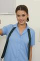 A woman in a blue shirt and green tie giving a thumbs up.