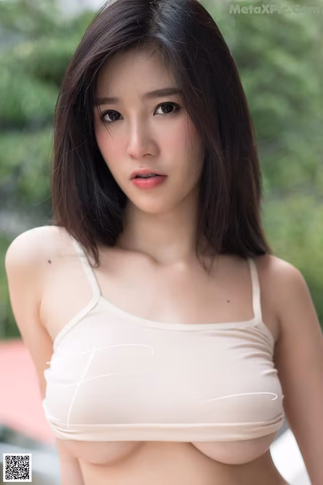 A woman in a white bra top posing for a picture.