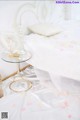 A white bed with a white headboard and a glass table.