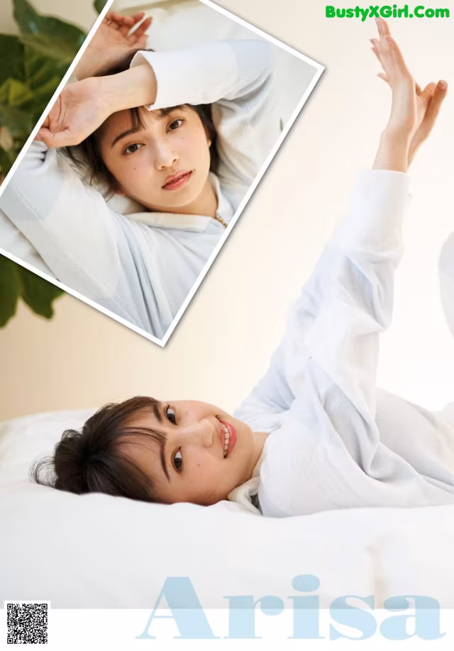 A woman laying on a bed with her hands behind her head.