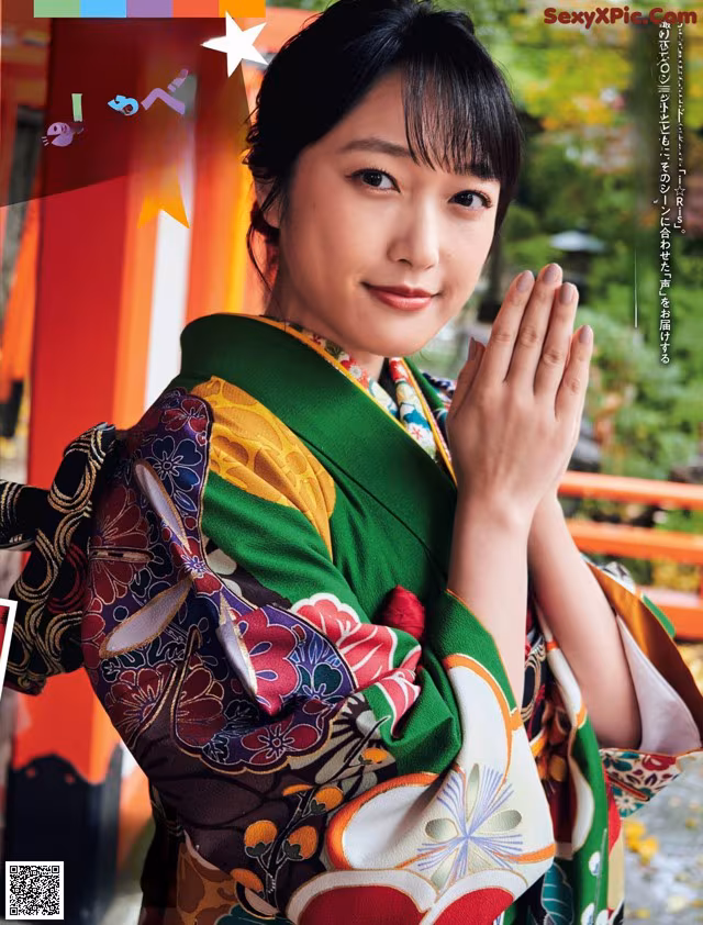 A woman in a colorful kimono is posing for a magazine.